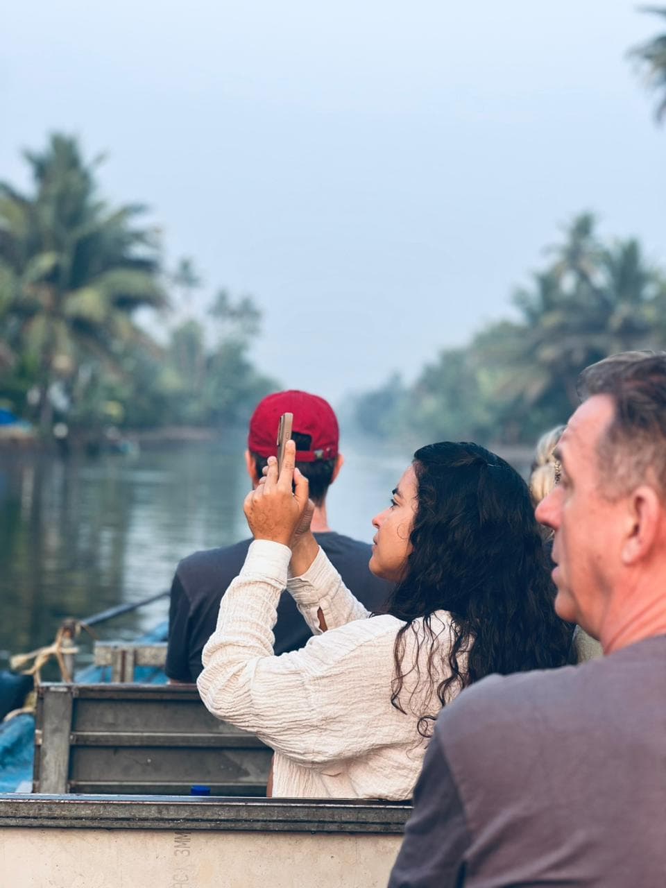 Group of travellers riding toward the sunset through a backwater canal