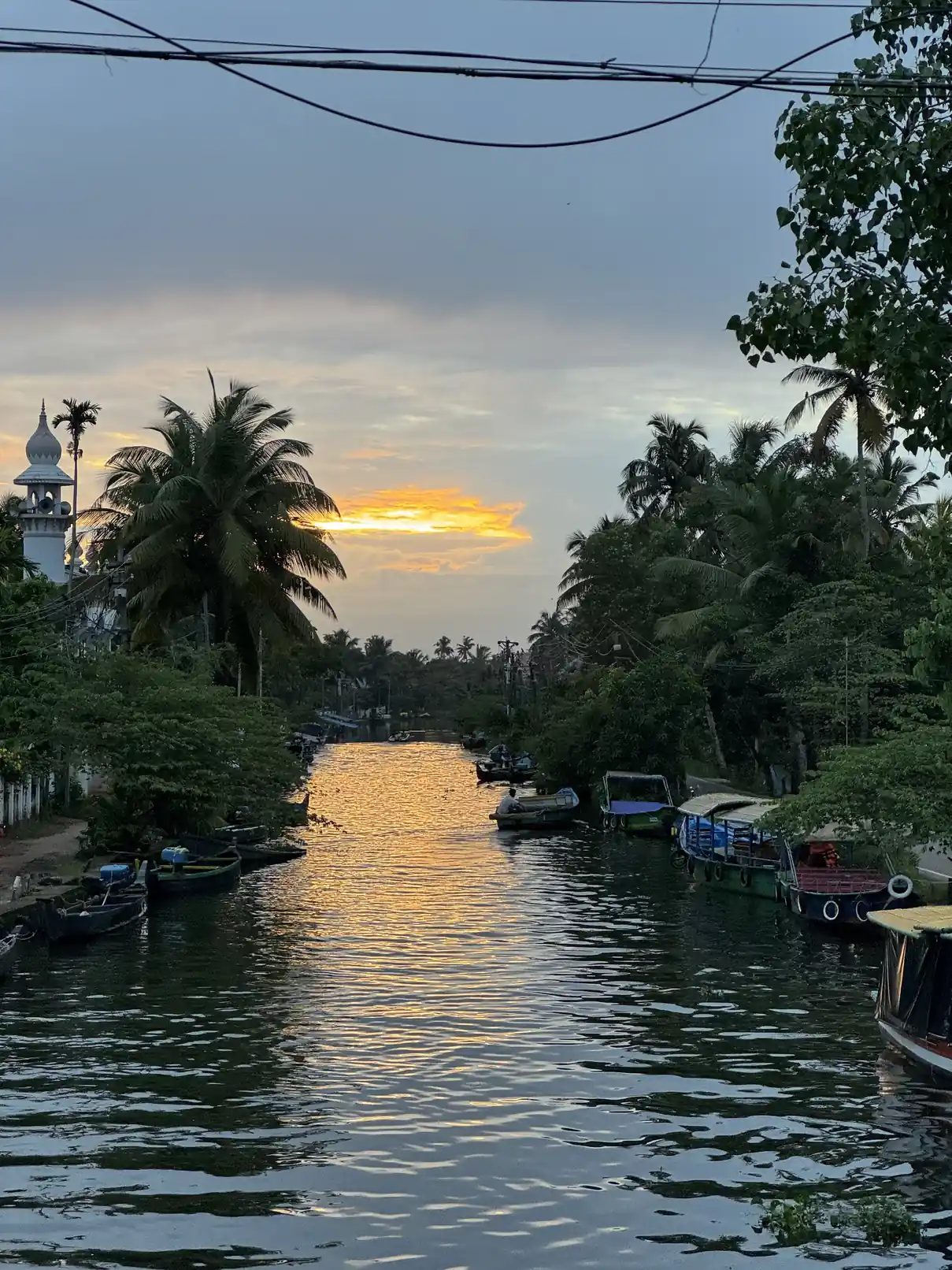 Still reflections in a narrow Alappuzha canal