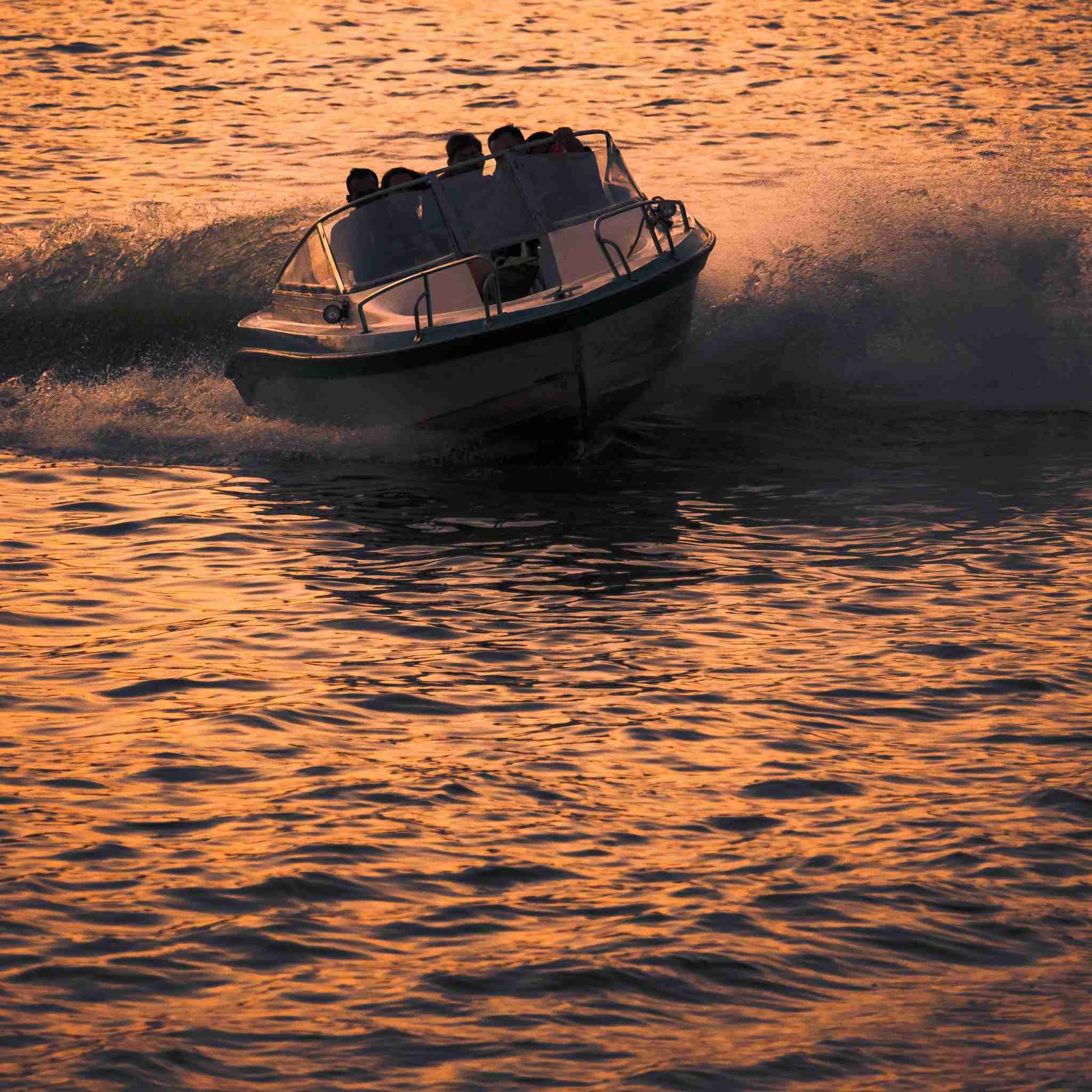 Private speed boat ride cutting through sunset-lit Alleppey backwaters