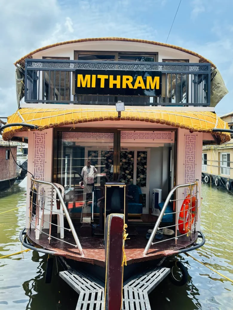 The one bedroom Premium houseboat Mithram moored at the jetty, with a two-level thatched roof